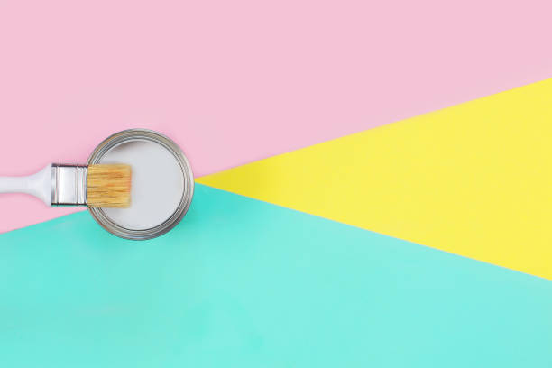 istock Open can with white paint and brush on color pastel background. 1251107200