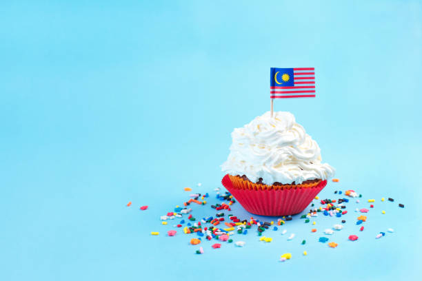 cupcake con blanco topping feliz día de malasia, 31 de agosto y bandera de malasia sobre fondo azul - downunder fotografías e imágenes de stock