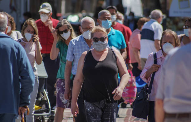 Group of people on the street Madrid, Spain - June 18, 2020: People are using mask in their new life routine about Covid-19 pandemic. covid crowd stock pictures, royalty-free photos & images