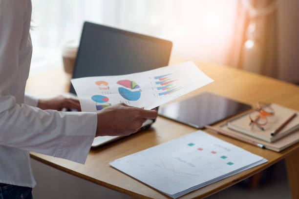 istock Businesswoman hands holding business documents papers, financial statistics reports graphs and charts at the office 1251111941