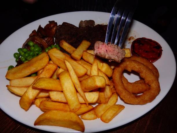 istock Medium fried rump steak with chips, peas, mushrooms, grilled tomatoes and onion rings 1251112043