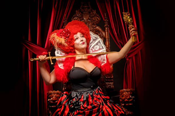 Queen of Hearts like female character on a throne in a studio shot