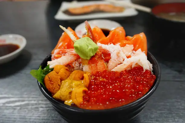 Photo of Premium set rice bowl with fresh raw seafood mix, crab, salmon, salmon eggs, uni serve together with wasabi, japanese tasty or kaisen don