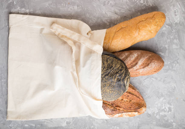 istock Reusable textile grocery bag with fresh baked bread on a gray concrete background. top view, flat lay, copy space. zero waste concept. 1251122085
