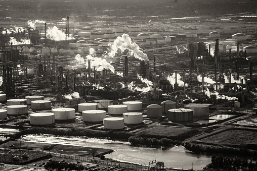 Aerial view of steam and smoke billowing out of smoke stacks at an oil refinery located just outside of Houston, Texas.