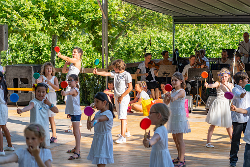 Elementary students performing a dance by holding multicolored lillipops in their hands on the 4th of july at Jugendfest Brugg 2019.