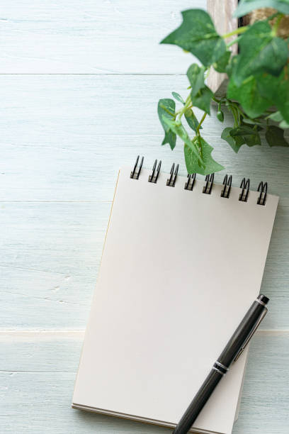 istock Notebook and pen on wooden background 1251127112