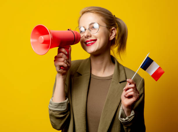 Style blonde woman in jacket with French flag and megaphone on yellow background Style blonde woman in jacket with French flag and megaphone on yellow background Universities in France stock pictures, royalty-free photos & images