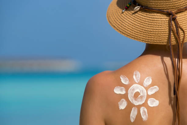 istock Woman with sun-shaped sun cream on beach 1251130726