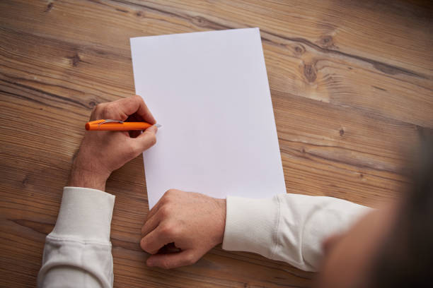 istock a man writes on a white sheet of paper 1251131680