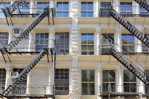 Low angle front view of famous fire escape ladders on colorful buildings located at Greene Street in SoHo district, New York City, USA