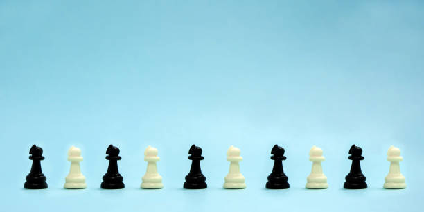 istock chess pieces, black and white pawns stand in a row on a blue background 1251132939