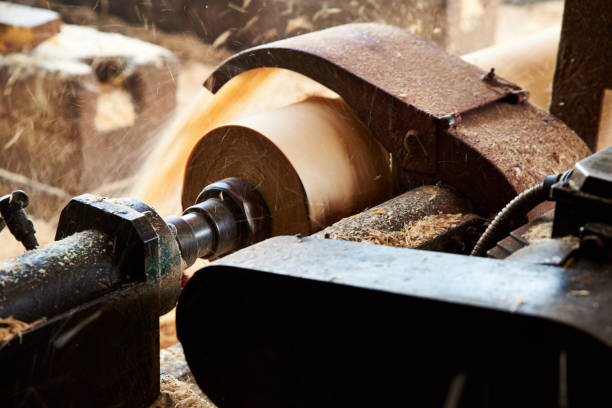 istock A saw machine cuts bark from wooden logs at a sawmill. 1251133565