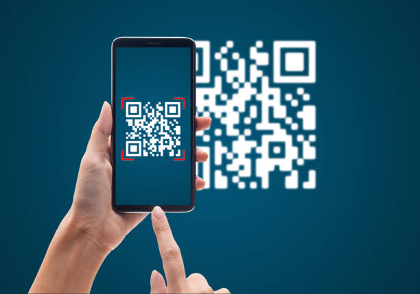 휴대 전화를 사용하여 손을 사용하면 파란색 배경에 qr 코드를 스캔합니다. 현금없는 기술 및 디지털 돈 개념 - qr코드 뉴스 사진 이미지