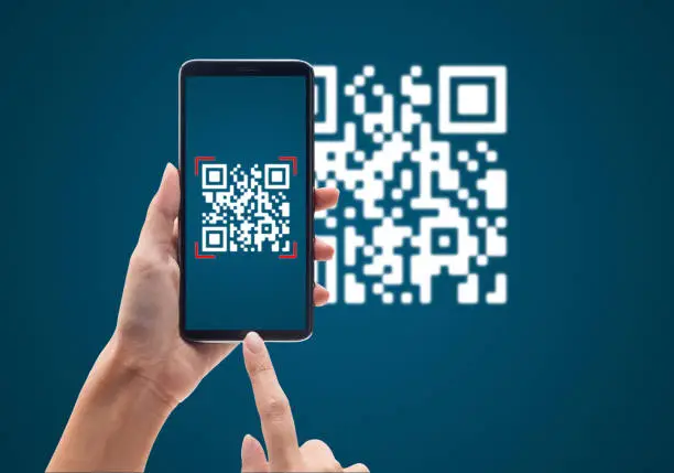 Photo of Hand using mobile smart phone scan Qr code on blue background. Cashless technology and digital money concept