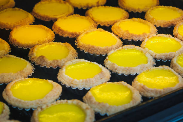 eiertorten auf metallteller, süßes dessert in bäckerei - - egg tart stock-fotos und bilder