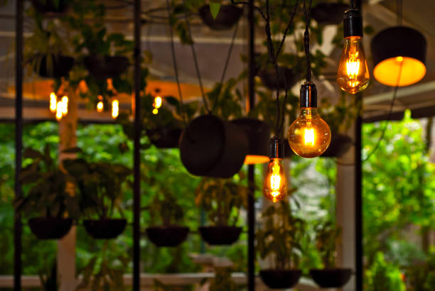 istock Yellow light bulbs as a design element. Greens and flowerpots in the background. Layout for interior design. 1251136477