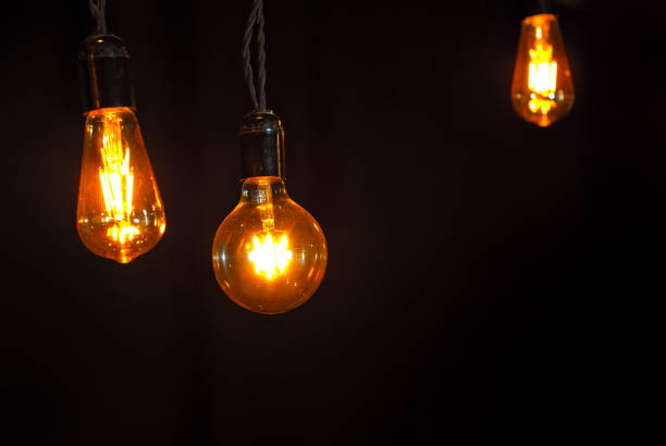 istock Yellow light bulb on a black background. Space for text and design layout. Copy space near light bulb. Mockup 1251136487