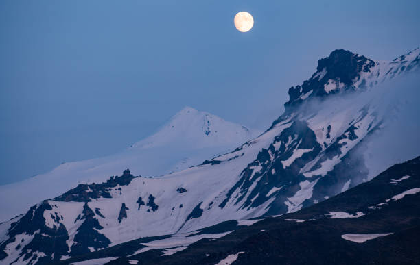 istock Golden full moon rising over distant mountains in the blue hour 1251138954