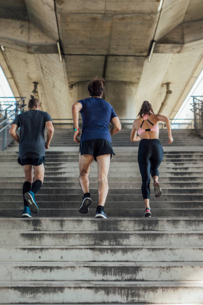 istock Back View of Three Determined Runners Exercising in an Urban Setting 1251139342
