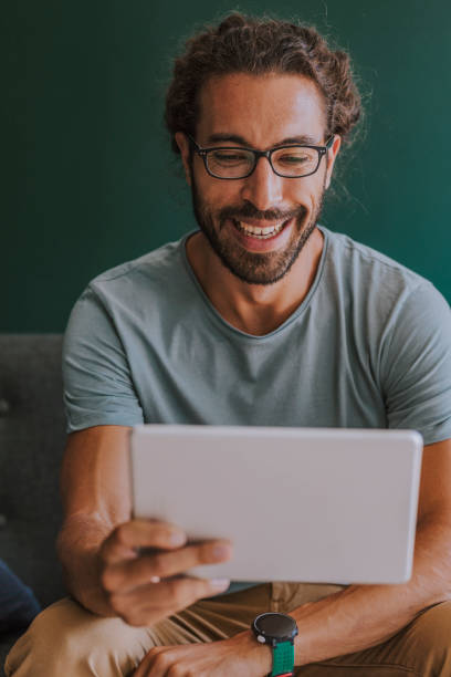 istock Happy Man  Watching Something on a Digital Tablet at Home 1251140973