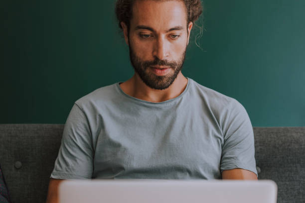 istock Handsome Man With a Beard Working on his Laptop at Home 1251141001
