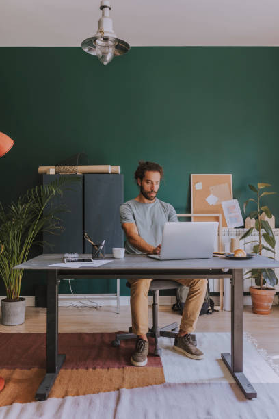 istock Telecommuting: a Casual Young Businessman Working from Home 1251141032
