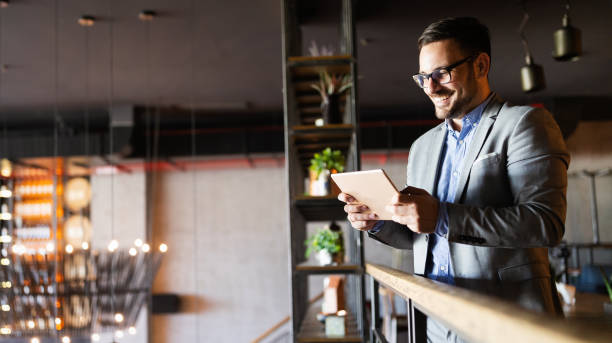 istock Happy businessman dressed in suit in modern office using tablet 1251141262