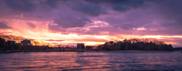 istock Dramatic twilight cloudscape panorama over Cape Cod Island. Blazing pink, orange, white sun rays illuminating the skyline over the horizon. 1251142193