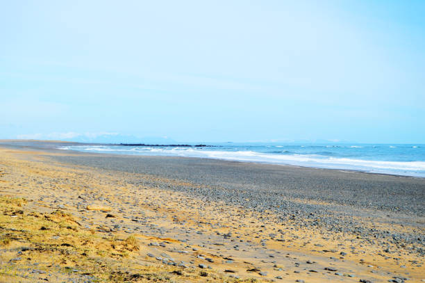 istock Amazing lonely and wavy beach with sand and rocks 1251144015
