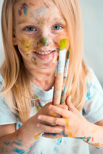 Funny portrait of small girl painter