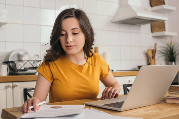 istock attractive freelancer looking at charts and graphs near laptop 1251146771
