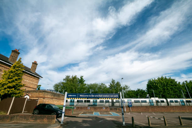 Bat and Ball Station in Sevenoaks, England, with a privately owned train service in the background and a car on the left.