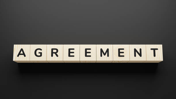 istock AGREEMENT word on wooden blocks on gray background. 1251151058