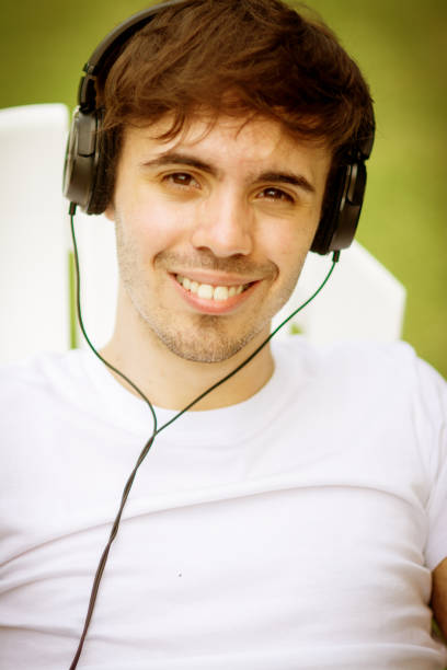 istock Young man using headphones and relaxing outdoors 1251151340