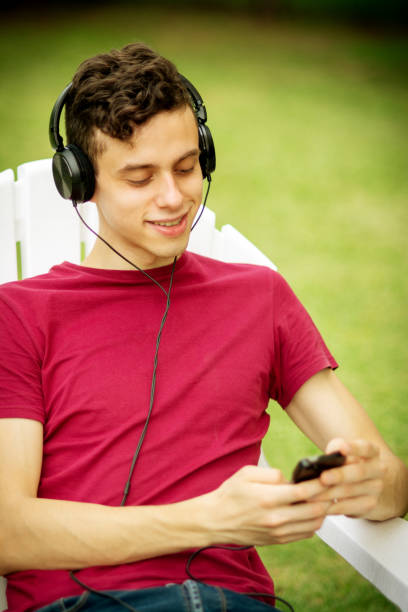 istock Young man using headphones and relaxing outdoors 1251151382