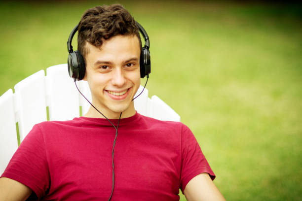 istock Young man using headphones and relaxing outdoors 1251151388