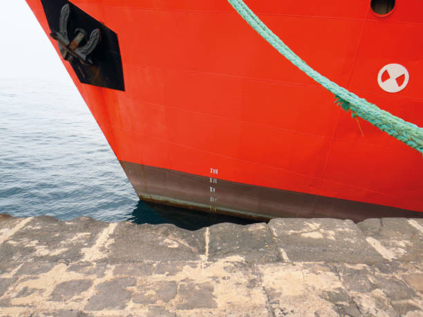 vue avant de proue d’un grand navire marchand rouge amarré au quai du port. corde attachée à la coque d’un navire de vraquier amarré dans un port. - yacht luxury front view ships bow photos et images de collection