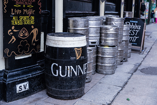 Dublin, Ireland - December 30, 2019: Stack of kegs of Guinness beer on the street outside an Irish pub in Dublin, Ireland