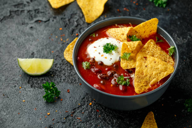 istock Mexican Chilli bean soup with yogurt, cheese and tortilla chips in black bowl 1251157019