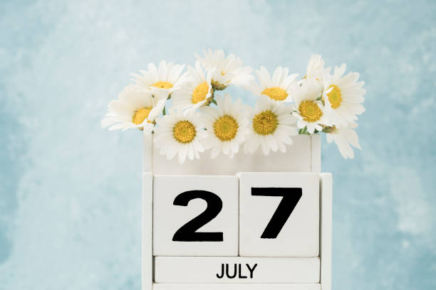 istock White cube calendar for july decorated with daisy flowers with copy space 1251158250