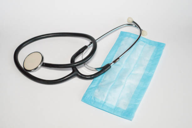 istock Stethoscope and blue disposable medical mask on white background 1251158417
