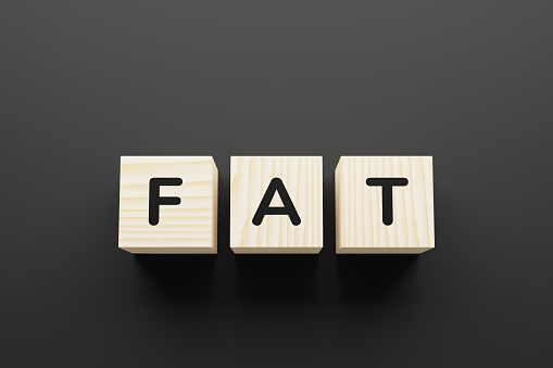 FAT word on wooden blocks on gray background.