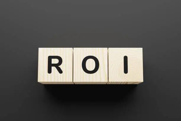 Photo of ROI word on wooden blocks on gray background.