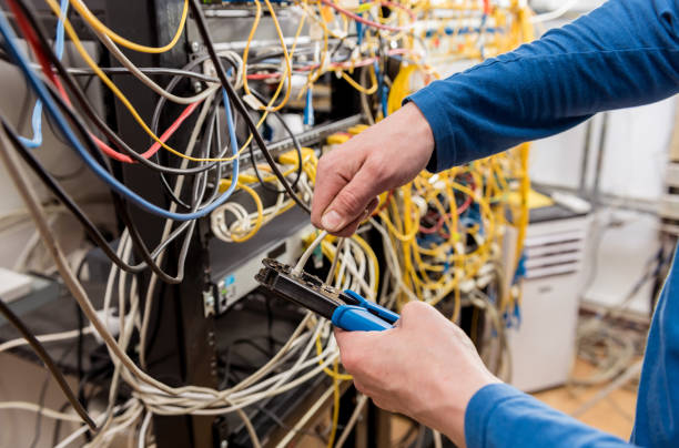 istock Network engineer working in server room. Connecting network cables to switches 1251161179