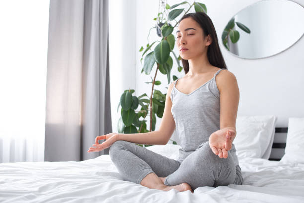 istock Calm young woman doing mental practice on bed 1251163559