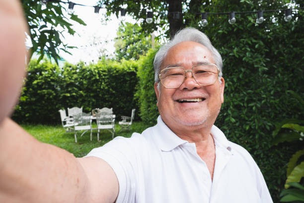 asiático hombre mayor selfie mientras videollamada con la familia - one senior man only grandfather portrait old fotografías e imágenes de stock