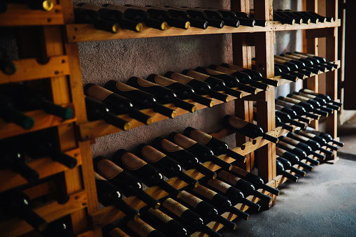 Wine bottles placed on a shelf in a wine cellar.
