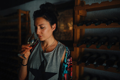 Woman tasting wine in the old winery.