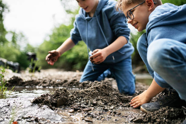 istock Little boys building little dam on a stream 1251170939